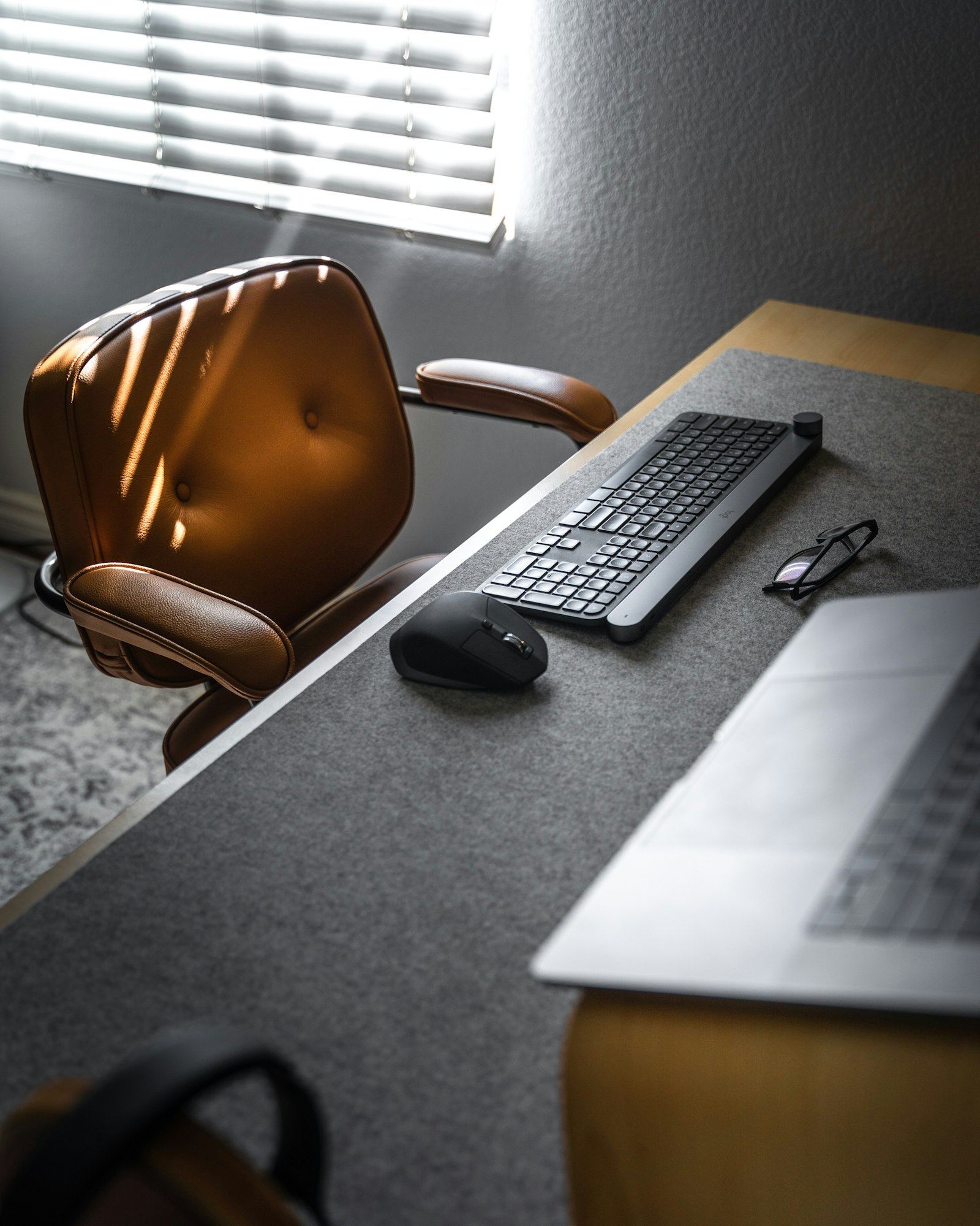 A quiet, minimal desk setup with a keyboard and mouse on a grey desk mat
